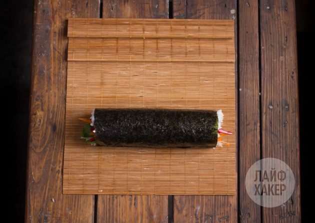 Sådan laver du en sushirrito: Brug et tæppe til at rulle rullen forsigtigt