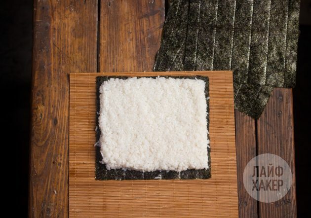 Sådan laver du en sushirrito: Læg et nori-blad på et tæppe og dæk det med et lag ris