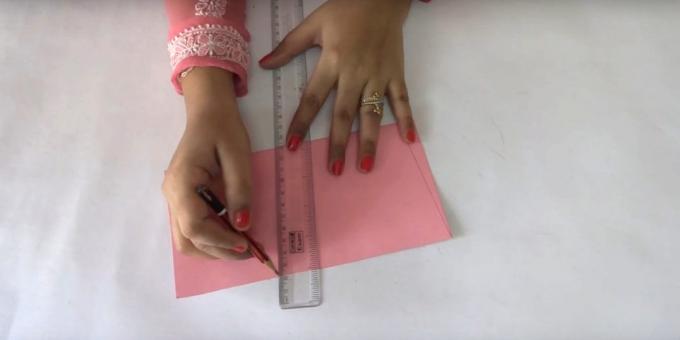 Fold lyserød ark papir i halve